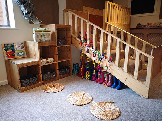 Wooden play steps, books and colourful toys in the Mulbarton nursery
