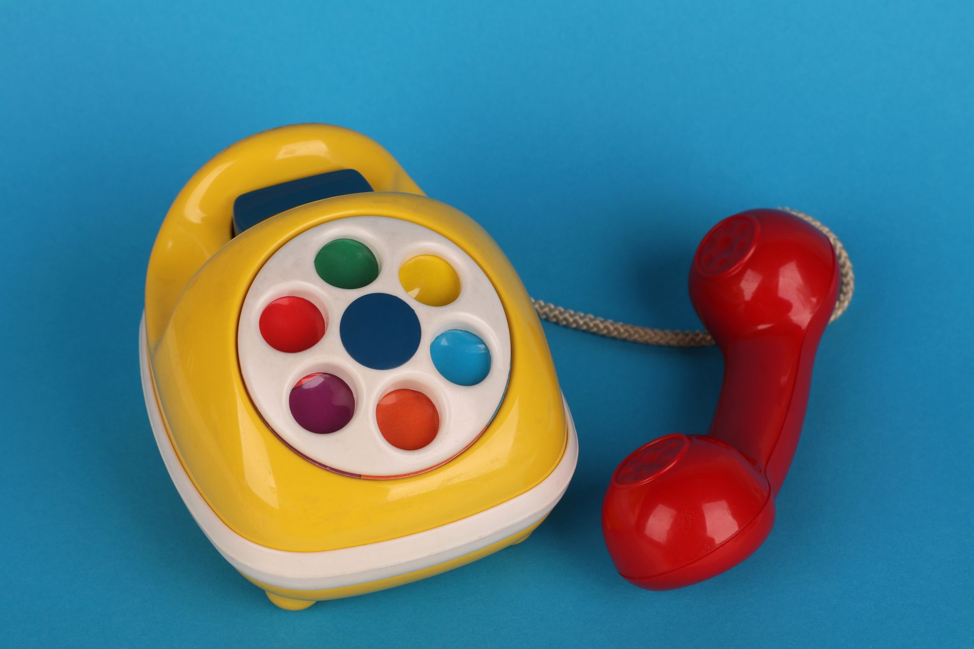 A colourful toy telephone on a blue background