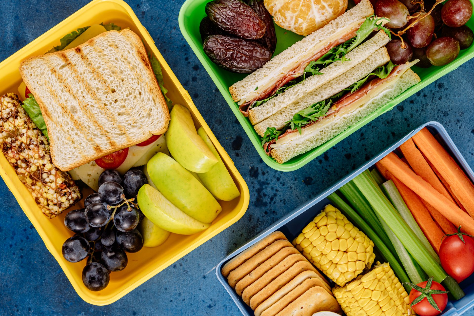 Colourful lunchboxes filled with sandwiches, fruit and vegetables