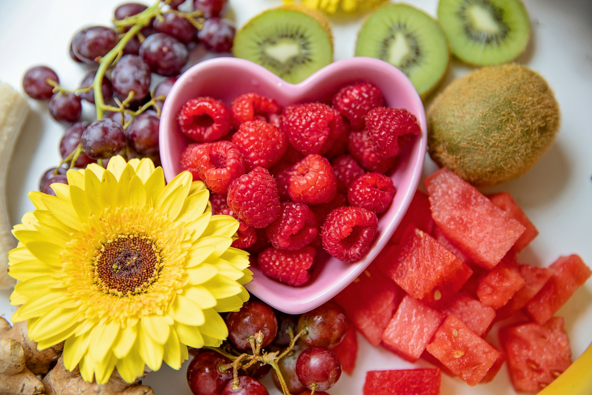 Fresh fruit with raspberries in a heart-shaped bowl